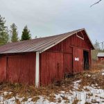 Ulkorakennuksen päätykuva, punamultamaalattu lautaverhous ja liukuovi