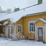 Keltaisen koulun kaksi sisäänkäyntiä ja talvinen piha-alue Aholantiellä.