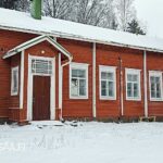Entisen punaisen koulurakennuksen puujulkisivu ja ikkunoita talvella Ikaalisten Kovelahdessa.