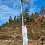 Myyntiesitteet ja Ostametsää.fi-kuitunauhat liehuvat Kartuntie-kyltissä