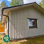 Vaalean omakotitalon pääty ja puuverhoiltu julkisivu, Ikaalinen Vatula