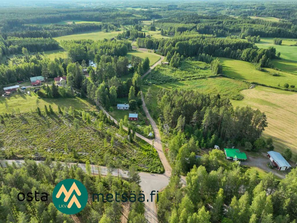 Ilmakuva omakotikiinteistön ympäristöstä metsien, peltojen ja teiden läheisyydessä