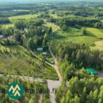 Ilmakuva omakotikiinteistön ympäristöstä metsien, peltojen ja teiden läheisyydessä