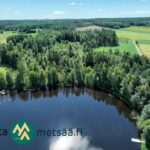 Dronekuva Saarilahden metsäisestä rantapalstasta ja sitä ympäröivistä pelloista Ikaalisissa