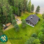 Ilmakuva huvilasta, piharakennuksista ja omasta järvenrannasta