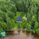 Ilmakuva talviasuttavasta huvilasta, rantasaunasta ja hiekkarannasta